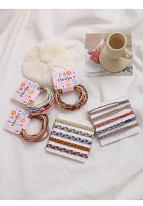 Detail view of woven elastic hair bands in macaron and earthy tones on display cards