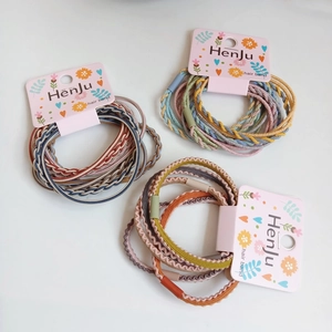 Detailed close-up of colorful braided and wavy elastic hair ties on a pink card