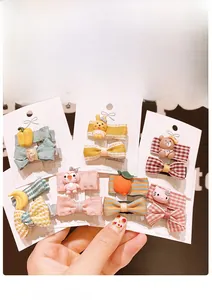 Detail of colorful cartoon hair clips featuring fabric bows and resin animal charms