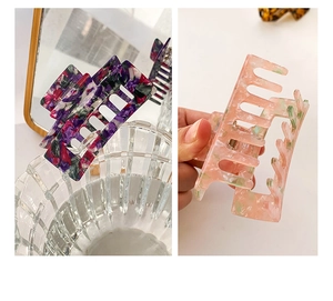 Detail of large acetate hair claws with marble texture and rectangular hollow design