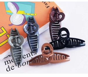 Close-up of heart-shaped hollow hair claws in various glossy colors with strong metal spring