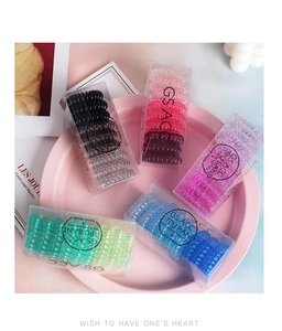 Close-up of multicolored TPU spiral hair ties set in a rectangular plastic gift box