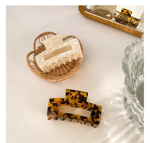 Detailed macro view of acetate hair claws in marble and tortoiseshell rectangle design
