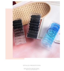 Macro shot of colorful spiral telephone cord hair ties in a clear plastic gift box