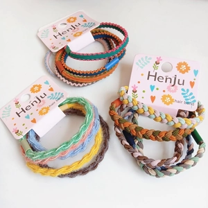 Colorful elastic hair band set with braided and wavy textures on a floral card display