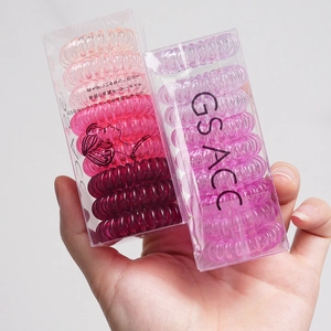 Assorted gradient telephone wire hair coils in a transparent plastic box container
