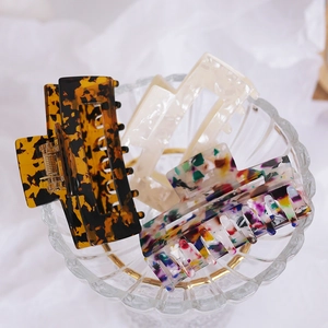 Set of three acetate hair claws in tortoise shell, marble white, and floral print patterns