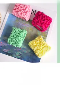 Macro detail of four colorful high-elastic bubble scrunchies displayed on an art book