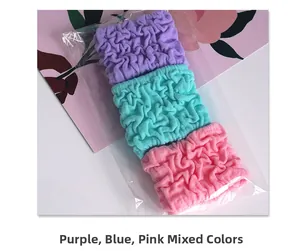 Detailed macro view of three colorful ruffled bubble hair ties in clear packaging