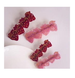 Vue détaillée de quatre barrettes fraises roses et rouges avec des strass scintillants