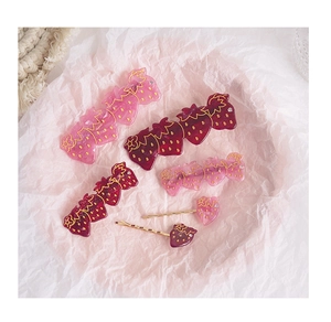 Détails de pinces à cheveux fraises avec paillettes et strass sur papier plissé violet