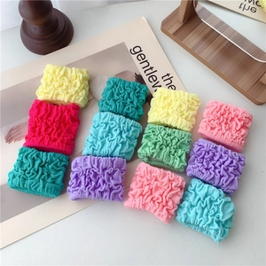 Set of 3 macaron bubble hair scrunchies in vibrant colors on a decorative magazine base