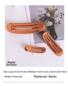 Three-piece set of matte orange resin hair clips in large, medium and small sizes