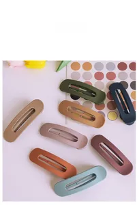 Detailed view of large matte hair clips in various Morandi colors and hollow oval design