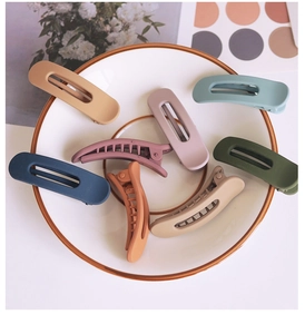 Set of 8 large matte hair clips in Morandi colors displayed in a ceramic dish