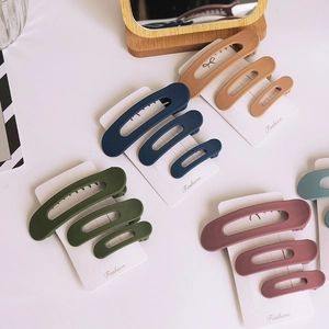Set of minimalist matte hair claws in various earthy tones on a stylish display card
