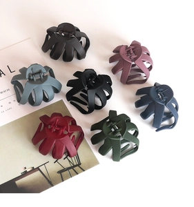 Matte octopus hair claw clips in various colors displayed on a minimalist magazine