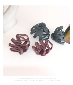 Close-up of four matte octopus hair claws in purple and teal shades for thick hair