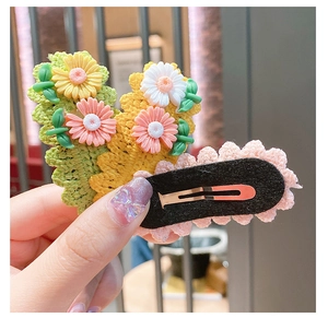 Detail of handmade knit floral hair clips featuring daisy patterns and metal BB back clips