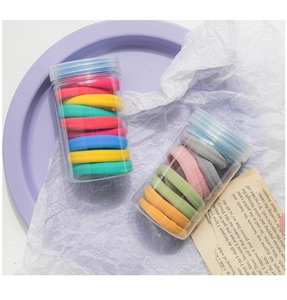 Close-up of colorful high-elastic seamless hair ties in a transparent plastic jar