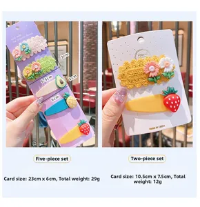 Detail showing various hand-knitted flower and fruit hair clips in multi-piece set packs