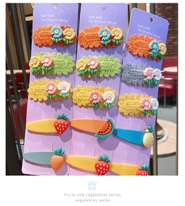 Detail of handmade crochet flowers and fruit hair clips set on display cards