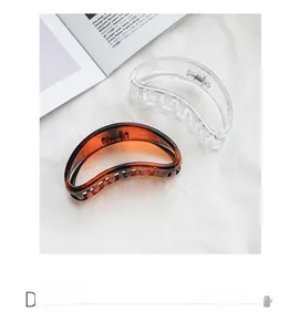 Detailed close-up of transparent and amber half-moon hair claws on fabric background
