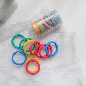 Colorful high-elastic seamless hair ties set with two clear storage jars on white paper