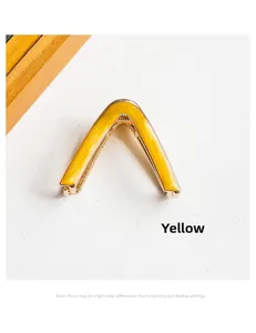 Detail view of yellow V-shaped hair claw with marble texture and golden metal base