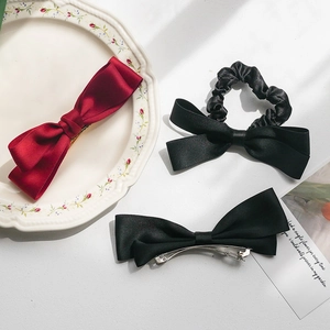 Three-piece satin bow hair accessory set with red and black clips and scrunchie