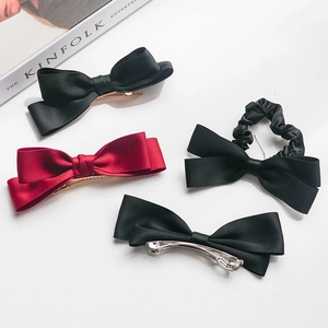 Elegant black and wine red satin bow hair clip set on a clean minimalist background