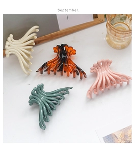 Detailed close-up of large octopus-style hair claws in tortoiseshell and pastel colors
