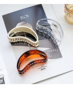 Detailed view of three minimalist resin hair claws in cream, clear, and tortoiseshell