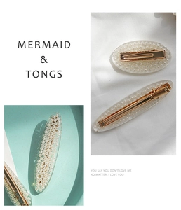 Close-up of pearl hair clips with mermaid style resin and gold metal ducksbill clip