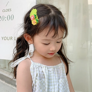 Cute crochet daisy hair clip for kids featuring green base with pink and yellow flowers