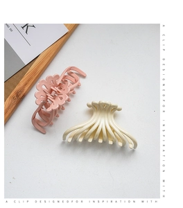 Detail of large jellyfish-shaped hair clips in cream and pink for updo hairstyles