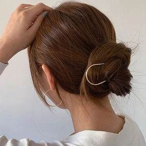 Minimalist gold U-shaped hair pin and round hoop earrings set shown on a model