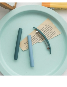 Trois barrettes à cheveux mates minimalistes en vert et bleu sur du papier vintage