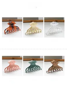 Detail showing octopus hair claw clips in amber, white, pink, green, and khaki colors