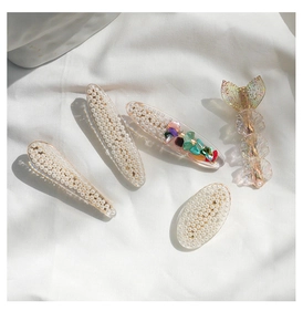 Close-up of a 5-piece set featuring pearl hair clips and mermaid tail resin designs