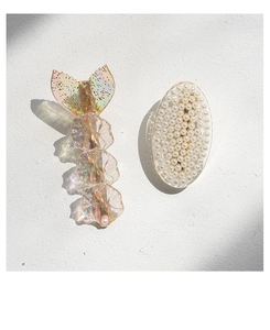 Detailed macro view of mermaid tail hair clip with iridescent resin and white pearl inlay
