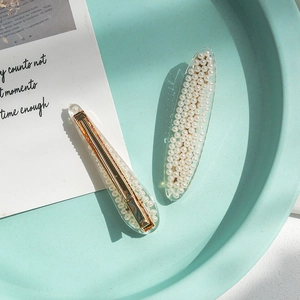 Elegant mermaid tail pearl hair clip set with white faux pearls on a gold metal base