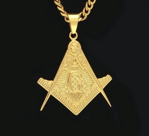 Macro shot of gold-plated Masonic pendant with square, compass, and letter G detail