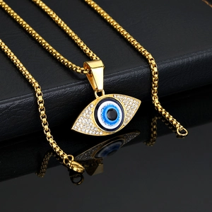 Collar de Ojo Turco dorado con circonitas y resina azul sobre fondo de cuero negro