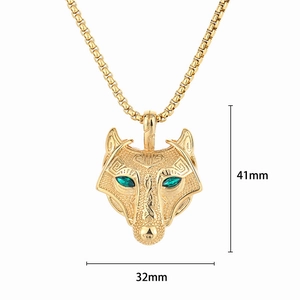 Detailed view of gold-plated Viking wolf head pendant with green gems and 41mm height