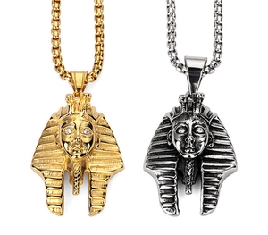 Detailed close-up of gold and silver Egyptian Pharaoh pendants with white crystal eyes