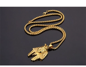 Detailed close-up of golden Egyptian Pharaoh pendant with sparkling eyes on a box chain