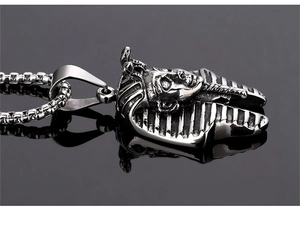 Macro detail of vintage stainless steel Egyptian Pharaoh pendant with intricate carvings