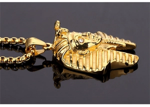 Macro detail of golden Egyptian Pharaoh Tutankhamun pendant with crystal eyes and box chain