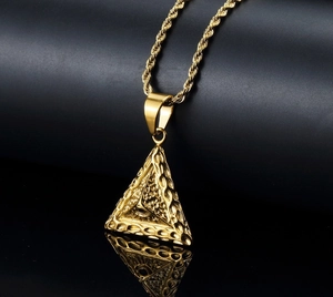 Macro-opname van vergulde roestvrijstalen piramide hanger met het alziende oog op ketting